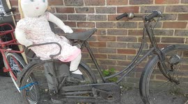 Classic old push bike looked funny with a Doll sat on the seat