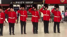 Group of male dancers dressed as Queen's guards entertain arrivals at Charing Cross station