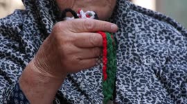An elderly Palestinian woman Ibtihaj Doula sits with her grandchildren at al-Shati refugee camp in Gaza city to mark Naksa Day