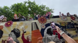 Celebrity filled buses representing the last 70 years arrive for the Platinum Jubilee Pageant.