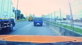 Excavator's wheel chock smashes into windscreen of car travelling behind it