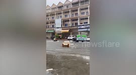 Couch surfing! Armchair and sofa float down flooded road after heavy rain in Cambodia