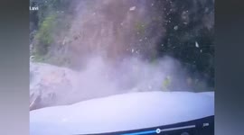 Rubble from landslide crashes onto road just in front of passing car in China