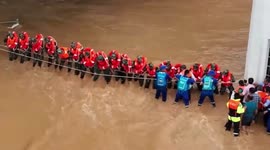 Firefighters form human wall to shield residents from floodwater in China