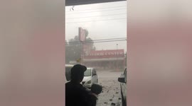 Shop sign collapses after being battered by tropical thunderstorm in the Philippines