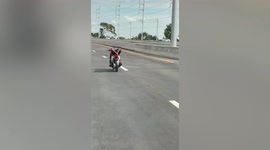 Motorcycle rider arrested for lying back on seat with no hands in Thailand