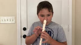 Boy plays flute with his nose