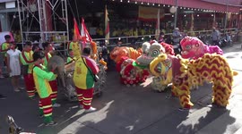 Buddhist devotees carry Chinese dragon along river in Thailand