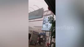 Storm blows huge billboard onto tuktuk driver during rush hour in Cambodia