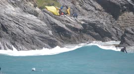 Cornwall's cliff dwelling homeless share their eyrie with surfers riding past and the holiday crowds at Towan beach Newquay Cornwall