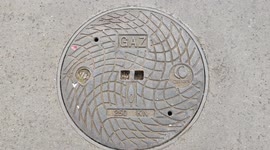 Pareidolia in Paris. Sewer drain face (gas). Rue Primatice, France. 12 june 2022.