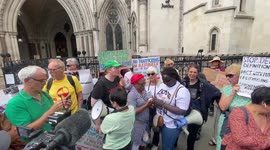 Newsflare Edit - Activists wait judgemebt to sto Rwanda plane outside court listening proceedings on moile pnone