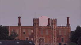 Paraglider appears just as Strawberry Supermoon rises over Gatehouse in Kent, UK