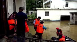 Police officers rescued residents trapped in village submerged by floodwater in China