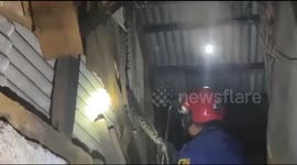 Firefighters remove python lurking inside wall at market in Indonesia