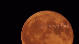 Jet captured passing in front of the full Strawberry Supermoon in Kent, UK