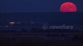 Stunning Strawberry Supermoon seen rising with pink hue above Kent, UK