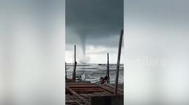 Large waterspout tornado shocks fishermen as it swirls off the coast of Indonesia