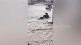 Passerby rescues scooter rider being washed down road by flood in China