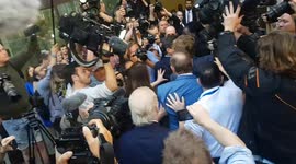 Media scrum surround actor Kevin Spacey as he arrives at Westminster Magistrates' Court