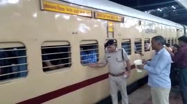Cops distribute glasses of water to passengers on train in central India