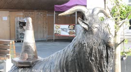 Statue of bronze goat wearing traffic cone permanently installed in London market square following public vote
