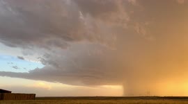 Lightning bolt, and explosive precipitation and hail core from storm at sunset near Keenesburg, Colo.