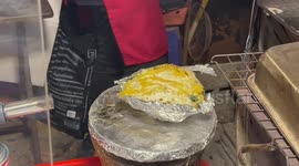 Flame-grilled baked potatoes sold on street food stand in Bangkok, Thailand