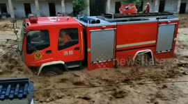 Fire engine swept down road with firefighters inside by flash floods in southern China