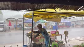 Sudden tropical storm downpour batters street food stall in Thailand