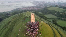 Crowds welcome the summer solstice at the Glastonbury Tor in Somerset