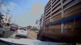 Street hawker dodges out-of-control truck barreling across road in Thailand