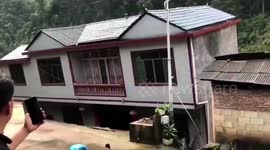 Chinese woman screams in terror as they watch their house collapse into floodwater