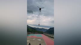 Helicopter delivers supplies to residents after rainstorm cuts off city in southern China