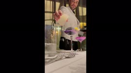 Very well dressed waiter pouring a spectacular cocktail with flourish