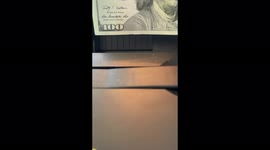 $100 bills being counted slowly on a money machine in slow motion
