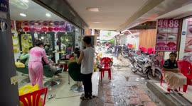 Locals have beauty treatments inside food market in Cambodia