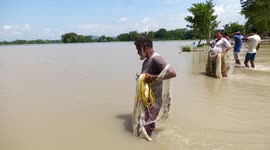 Locals fish on severely flooded road in northeastern India