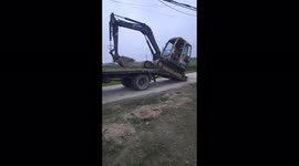 Excavator driver move excavator onto truck quickly on the narrow road