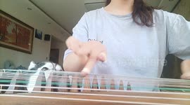 Husky howls along as owner plays Chinese instrument