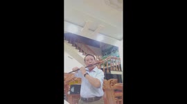 Vietnamese man with a missing arm plays the bamboo flute professionally.