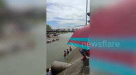 Frantic residents flee overloaded bridge as it tilted while they watched river parade below