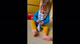'Adorable baby girl struggles BIG TIME with putting a sock on '