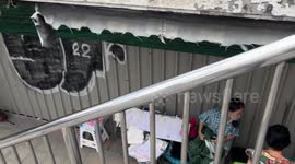 Street vendors casually sell goods under building during active DEMOLITION