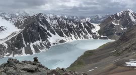 Beautiful panorama from the Ala Kul pass (3800m) to the frozen lake and snowy mountains.