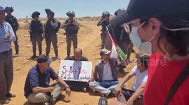 Palestinian demonstrators block road of Israeli soldiers during protest against settlements