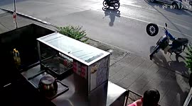 Loose wheel rolls into motorcycle parked outside food shop