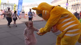 Piter cat is dancing and playing with a little girl on Palace square, St Petersburg, Russia