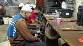Palestinian workers sharp knives at a workshop ahead of Eid al-Adha in Gaza city