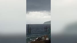 Thin waterspout triggers tornado warning as it crosses over onto Philippines coast